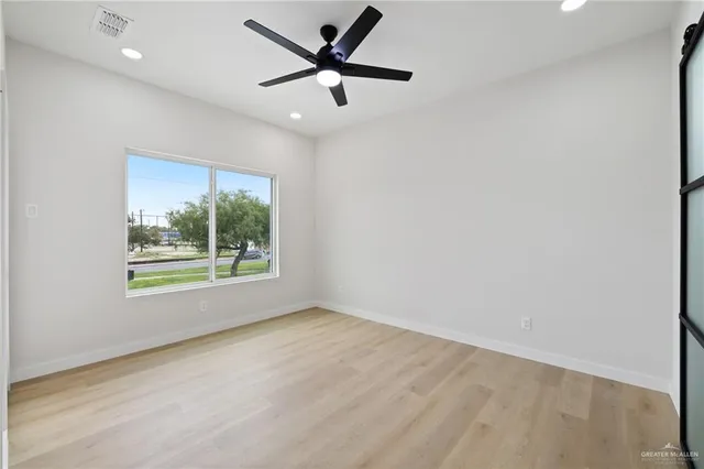 an empty room with a window and a fan