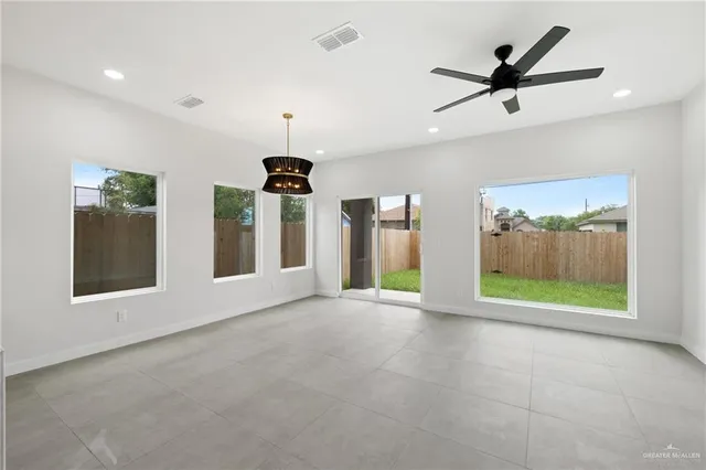 a view of an empty room with a window and a ceiling fan