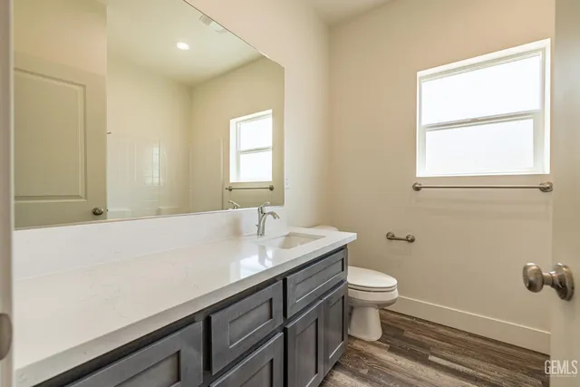 a bathroom with a sink a toilet and a window