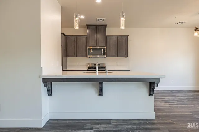 a kitchen with kitchen island a sink stainless steel appliances and cabinets