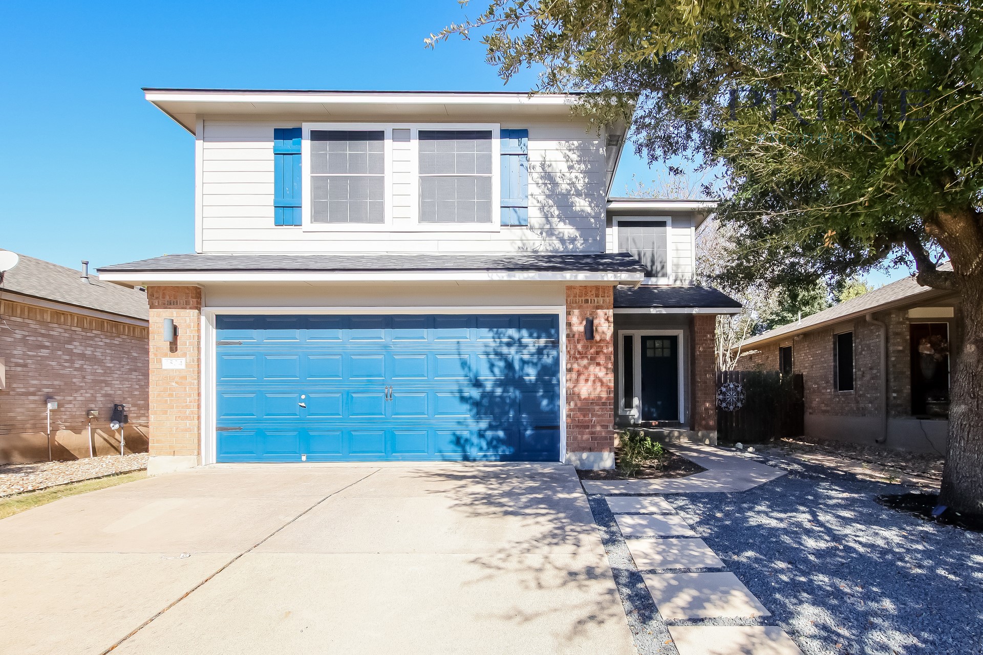 View of front facade with brick siding, a garage, and driveway