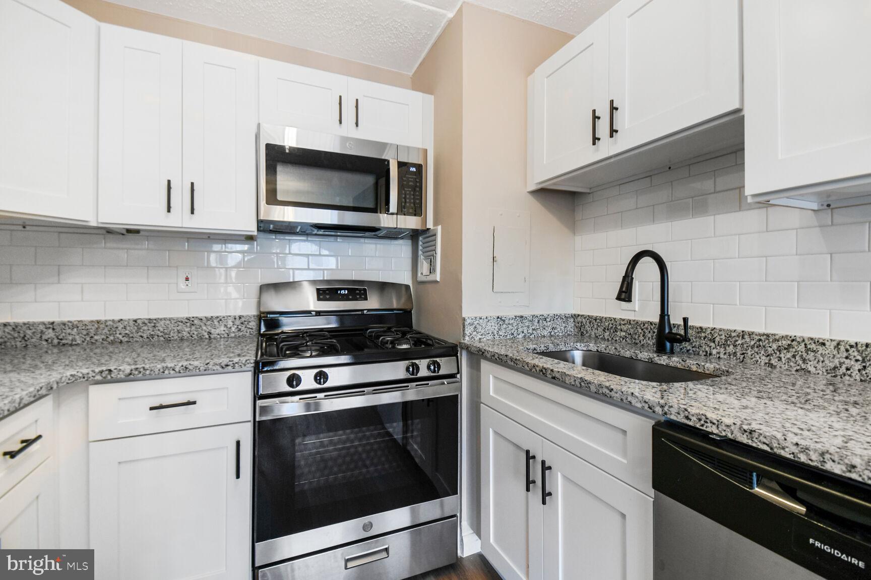 1804 Metzerott Road, Unit 106 Silver Spring, MD 20903 - Photo 6 of 15 a kitchen with granite countertop a sink and a stove top oven