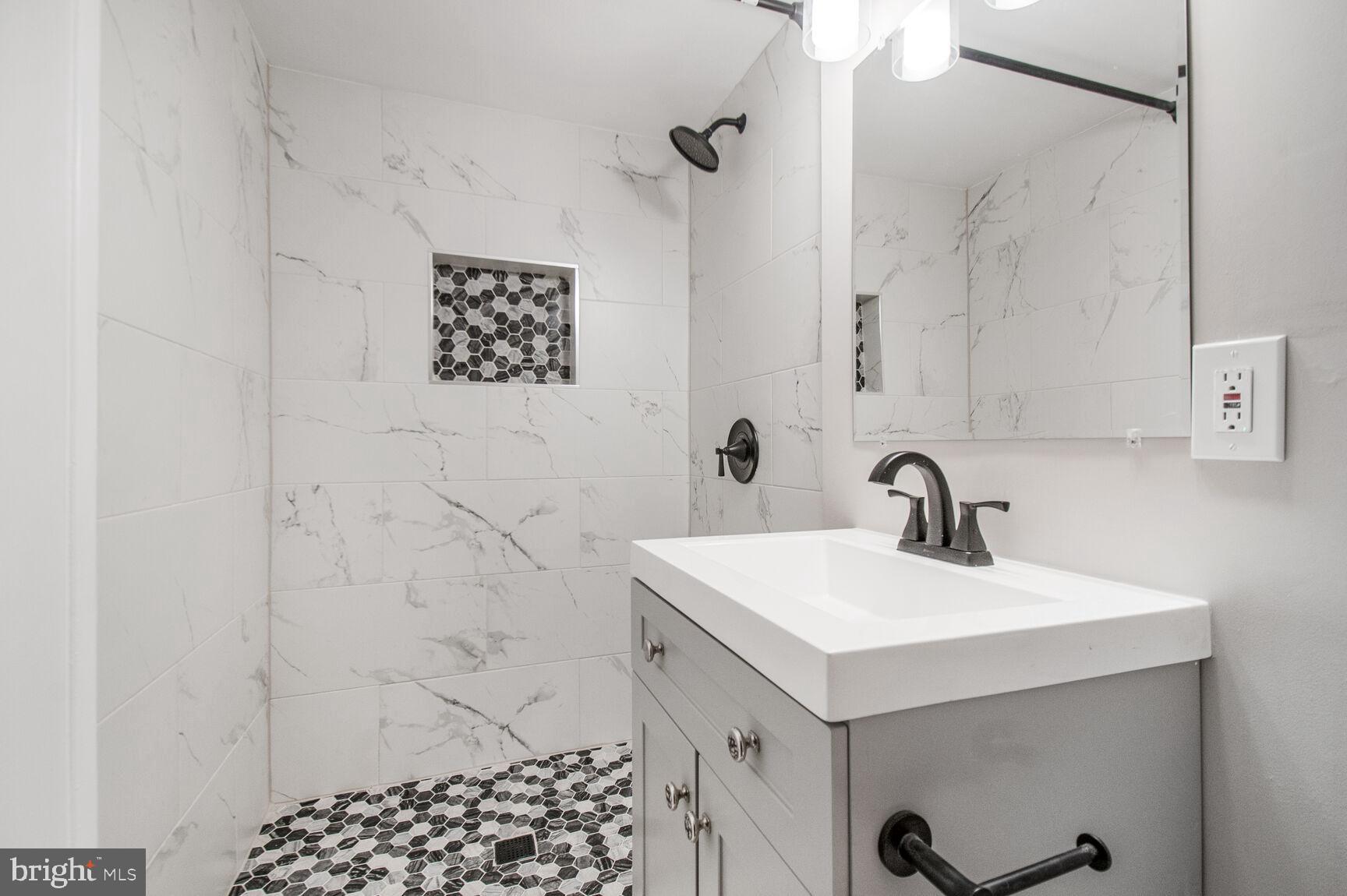 1804 Metzerott Road, Unit 106 Silver Spring, MD 20903 - Photo 10 of 15 a bathroom with a sink a mirror and shower