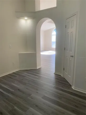 a view of empty room with wooden floor