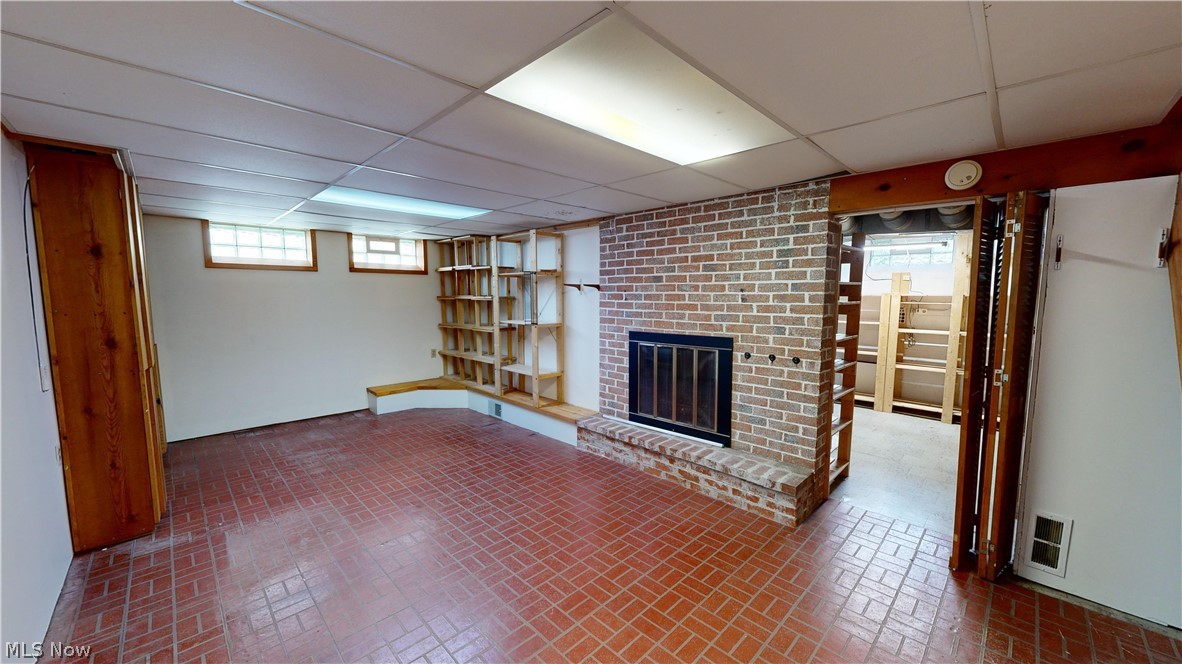 1508 Edgefield Road Lyndhurst, OH 44124 - Photo 19 of 28 Rec room featuring brick wall, a paneled ceiling, and a fireplace