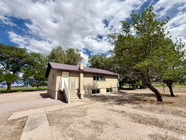 2865 North 3250 W Road Sutherland, UT 84624 - Photo 27 of 28 Two-story residence featuring a brown metal roof and a beige stucco exterior