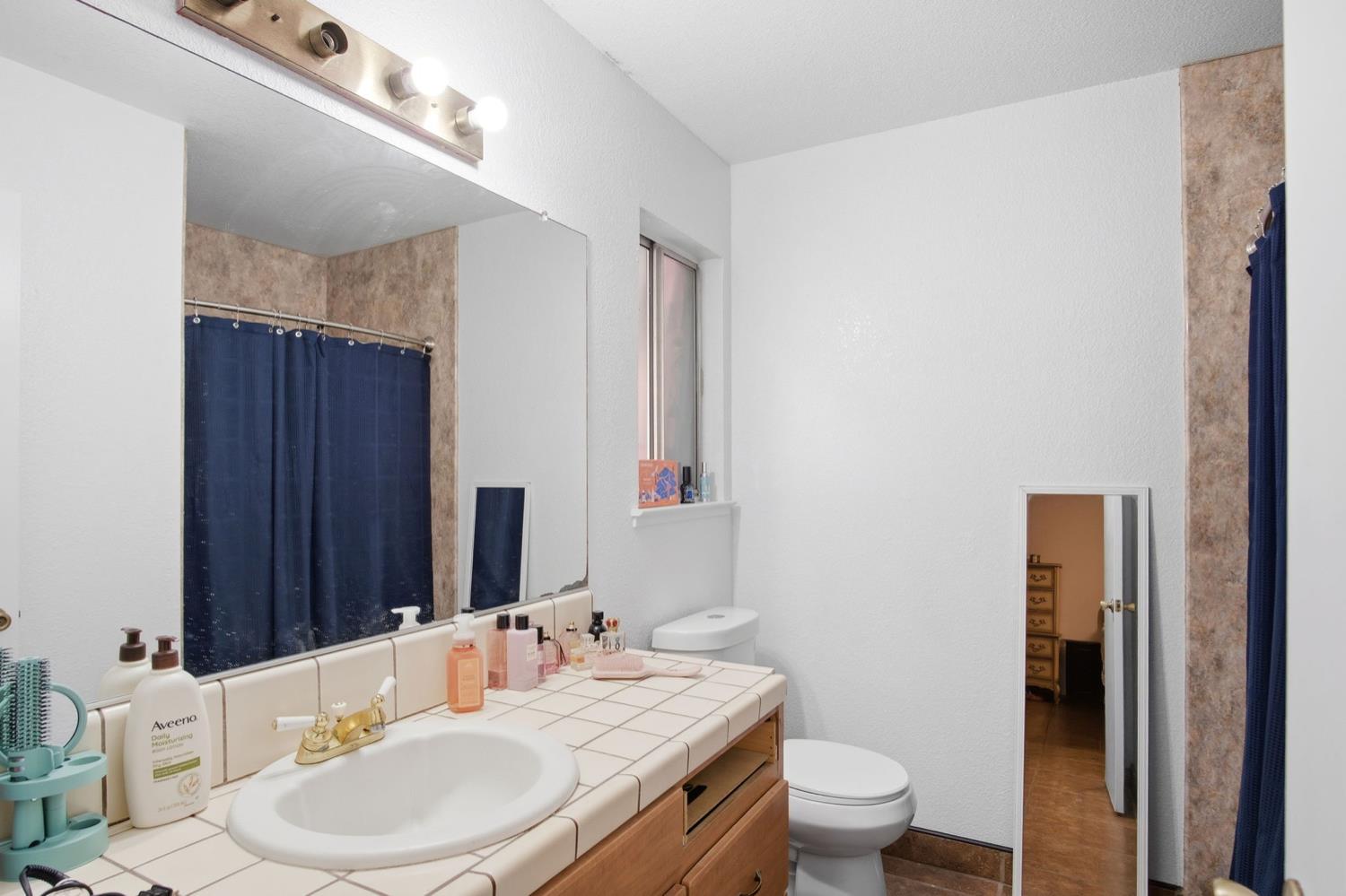1429 Don Pedro Road Ceres, CA 95307 - Photo 17 of 21 a bathroom with a sink a toilet and shower curtain