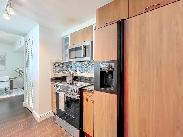 a kitchen with stainless steel appliances granite countertop a stove a washer and dryer