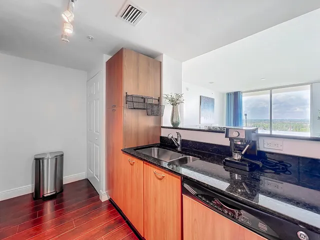 a kitchen with stainless steel appliances granite countertop a sink a stove and a refrigerator