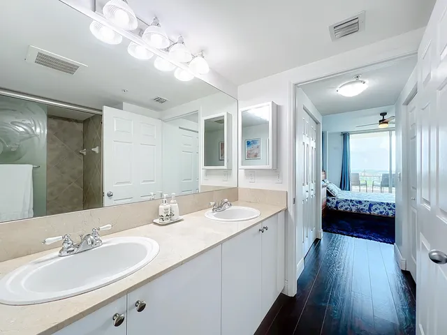 a en suite bathroom with double vanity a sink and a mirror