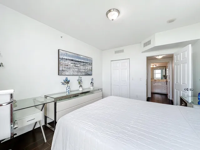 a bedroom with a bed and a lamp on dresser