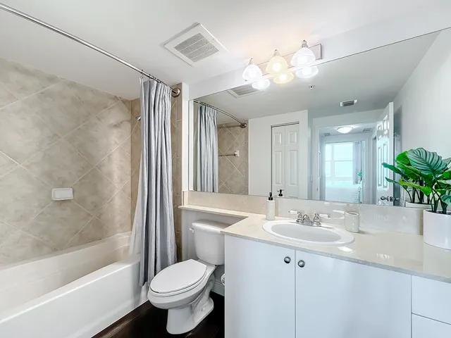 a bathroom with a sink a toilet and a large mirror