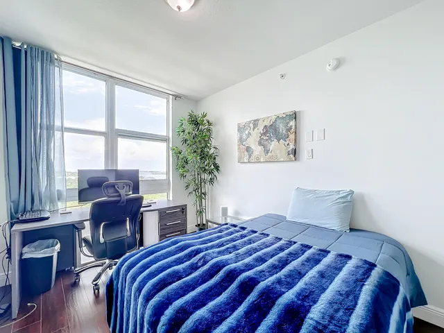 a bedroom with a large bed and a window