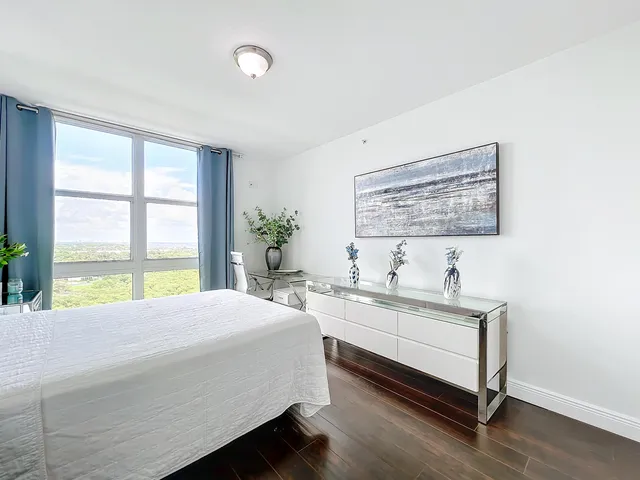 a bedroom with a bed and a large window