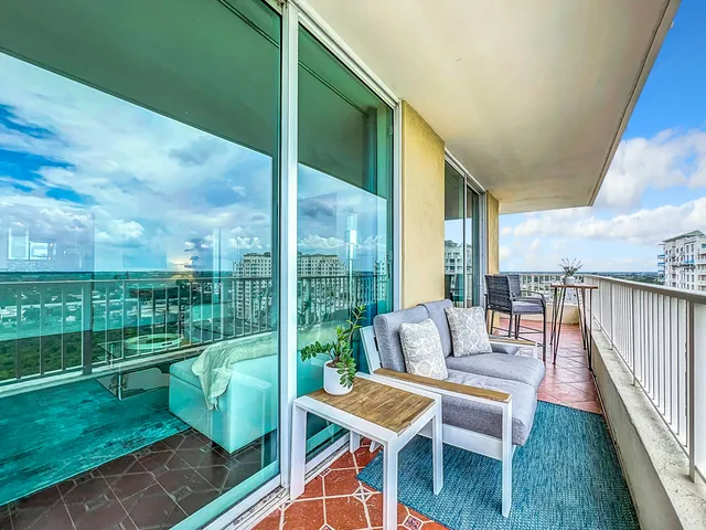 a balcony with chairs and city view