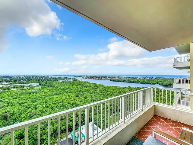 a view of a balcony with wooden floor & fence