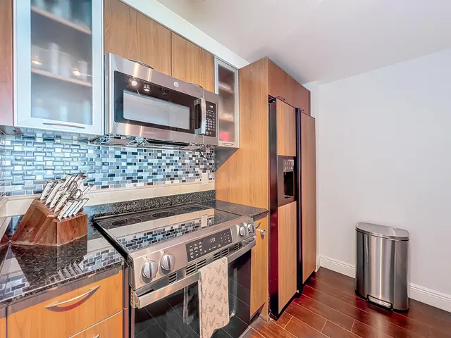 a kitchen with wooden cabinets and a stove top oven