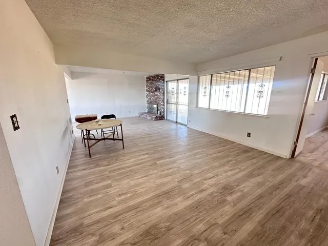 a view of a livingroom with wooden floor and furniture
