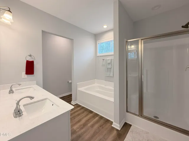 a bathroom with a tub sink and mirror