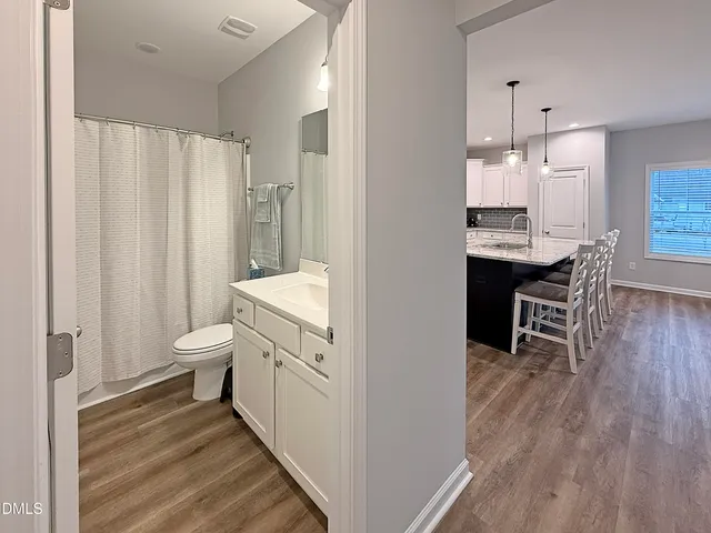 a bathroom with a sink a toilet a mirror and shower