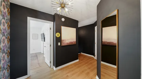 a view of a hallway with wooden floor and closet