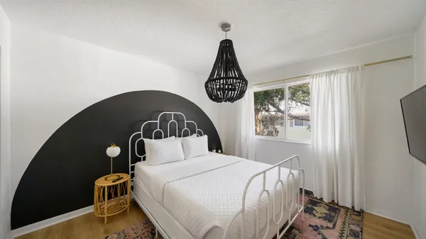 a bedroom with a bed and wooden floor