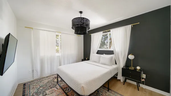 a bedroom with a bed and a chandelier