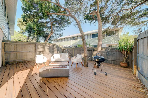 a view of a deck with couches table and chairs with wooden floor and fence