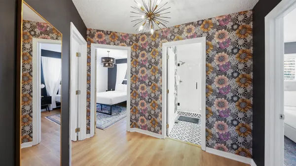 a view of a hallway with bathroom and wooden floor