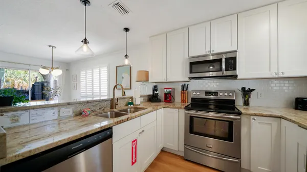 a kitchen with granite countertop a sink a stove and microwave