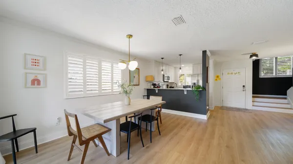 a kitchen with a table chairs and wooden floor
