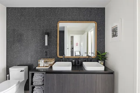 a bathroom with a granite countertop sink and a mirror