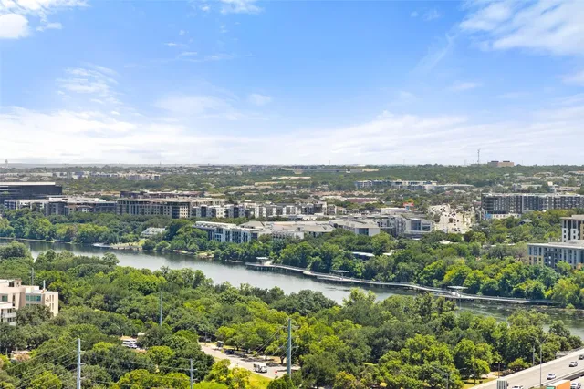 an aerial view of residential houses with outdoor space and trees