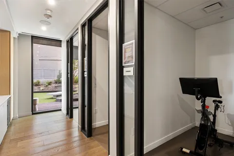 a view of a room with gym equipment and floor to ceiling window