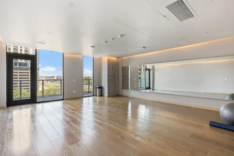 a view of an empty room with window and wooden floor