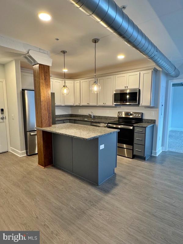 50 North Duke Street, Unit 305 York, PA 17401 - Photo 2 of 10 a kitchen with stainless steel appliances granite countertop a stove a refrigerator a sink a microwave and wooden cabinets