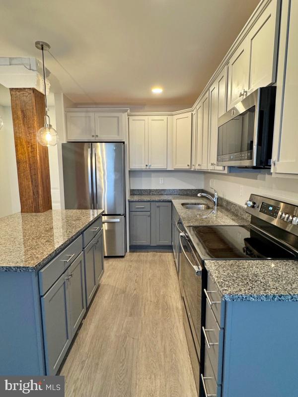 50 North Duke Street, Unit 305 York, PA 17401 - Photo 3 of 10 a kitchen with stainless steel appliances granite countertop a sink stove and refrigerator