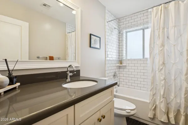a bathroom with a double vanity sink toilet and shower