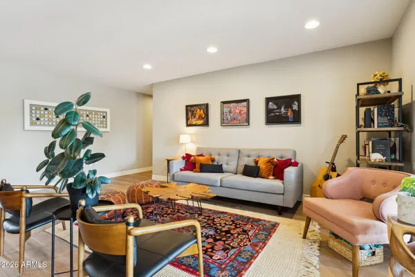 a living room with furniture and a bookshelf with wooden floor