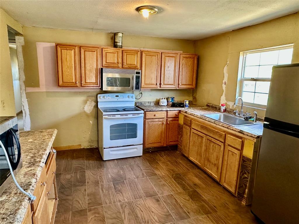 1314 Old Country Road Moody, TX 76557 - Photo 4 of 12 a kitchen with stainless steel appliances granite countertop a stove sink and microwave