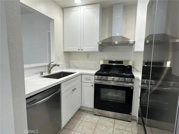 a kitchen with granite countertop a stove sink and cabinets