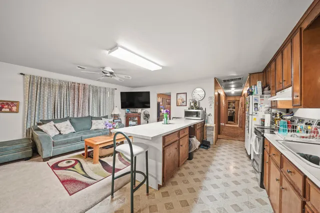 a large white kitchen with a large window and stainless steel appliances