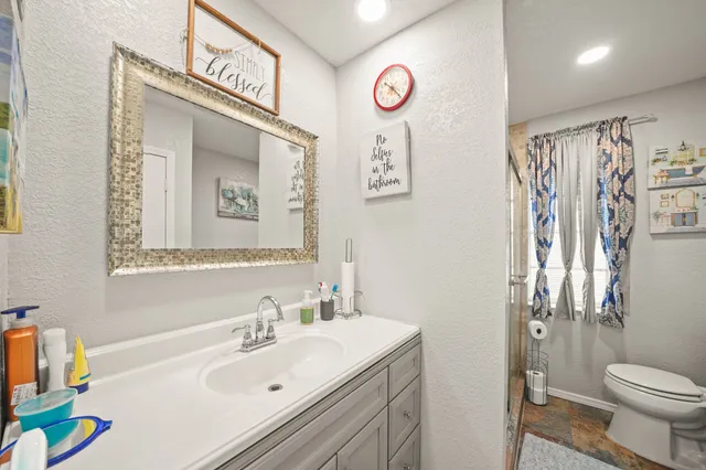 a bathroom with a sink mirror vanity and toilet
