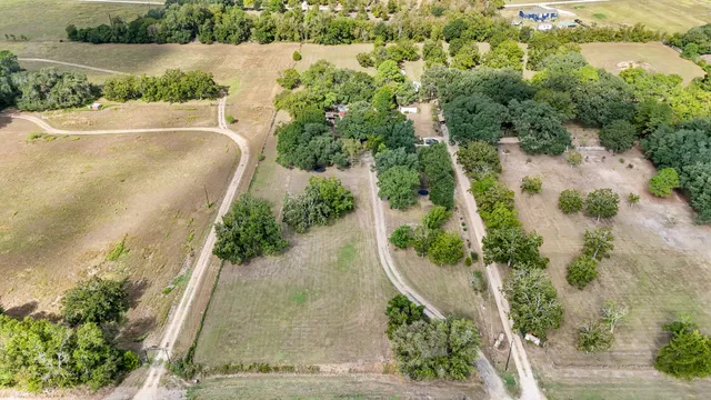 an aerial view of a residential houses with yard