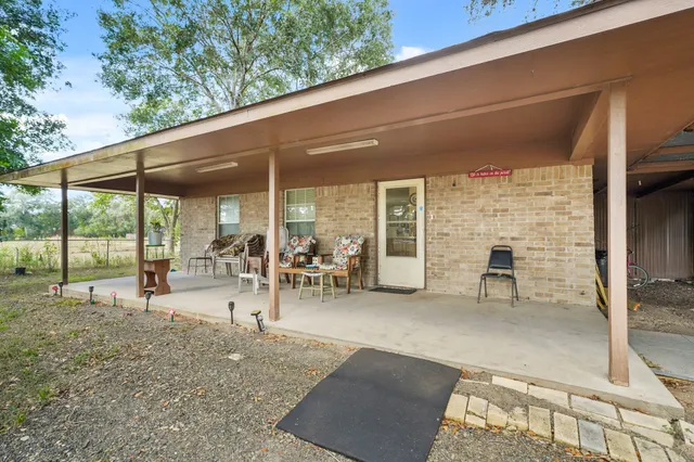 a view of a patio with table and chairs under an umbrella