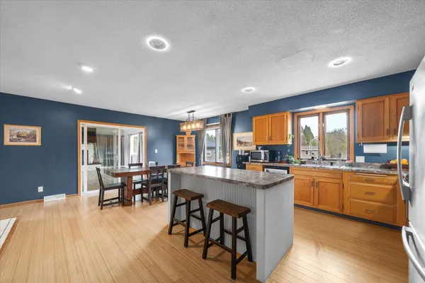 a kitchen with stainless steel appliances granite countertop a refrigerator a stove top oven a sink and dishwasher