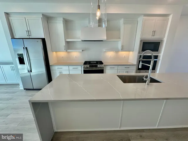 a kitchen with kitchen island a stove a sink and a refrigerator