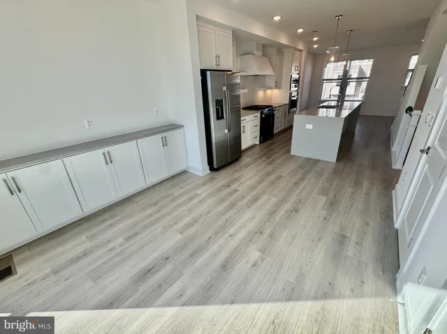 a open kitchen with stove and white cabinets