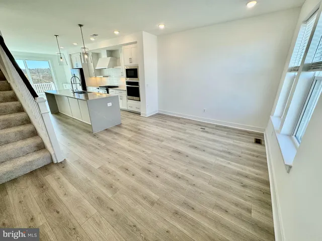 a view of a kitchen with wooden floor and electronic appliances
