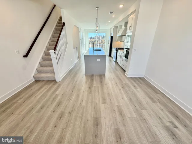 a view of a hallway with wooden floor and stairs